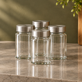 Four clear spice jars with silver-colored lids
